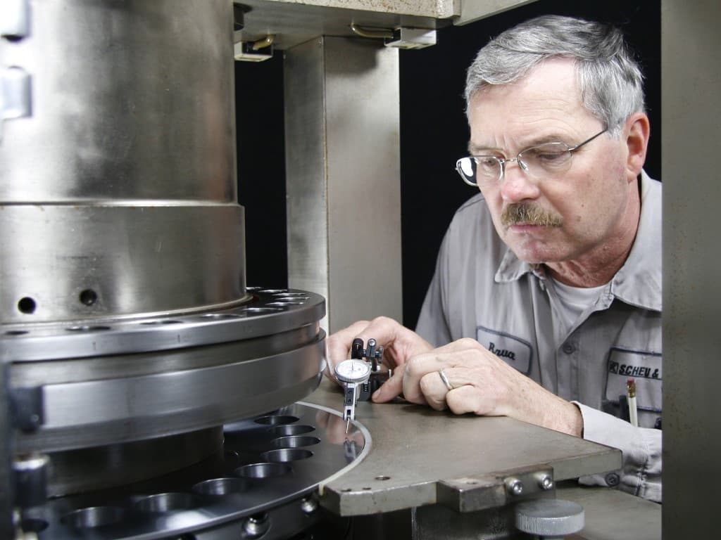 Scheu & Kniss technician inspecting a tablet press turret