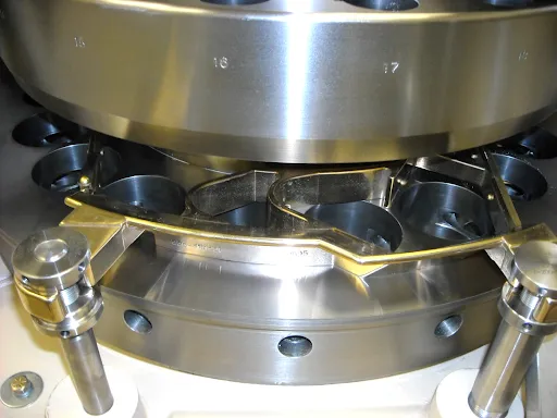 A close up shot of the scraper blade and feeder on the die table.